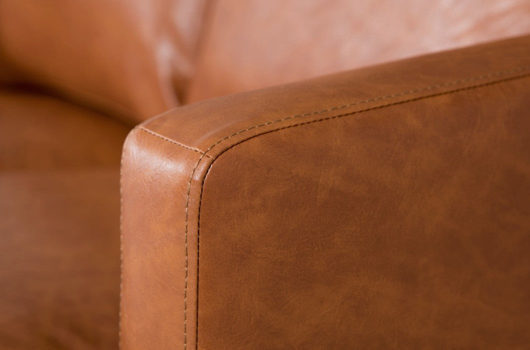 Close-up of a brown leather armchair corner. Commercial Interiors , contract sofa. 