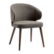 Selma Armchair - Grey features a curved upholstered backrest and seat with textured fabric and slender wooden legs, designed for comfort and modern style.