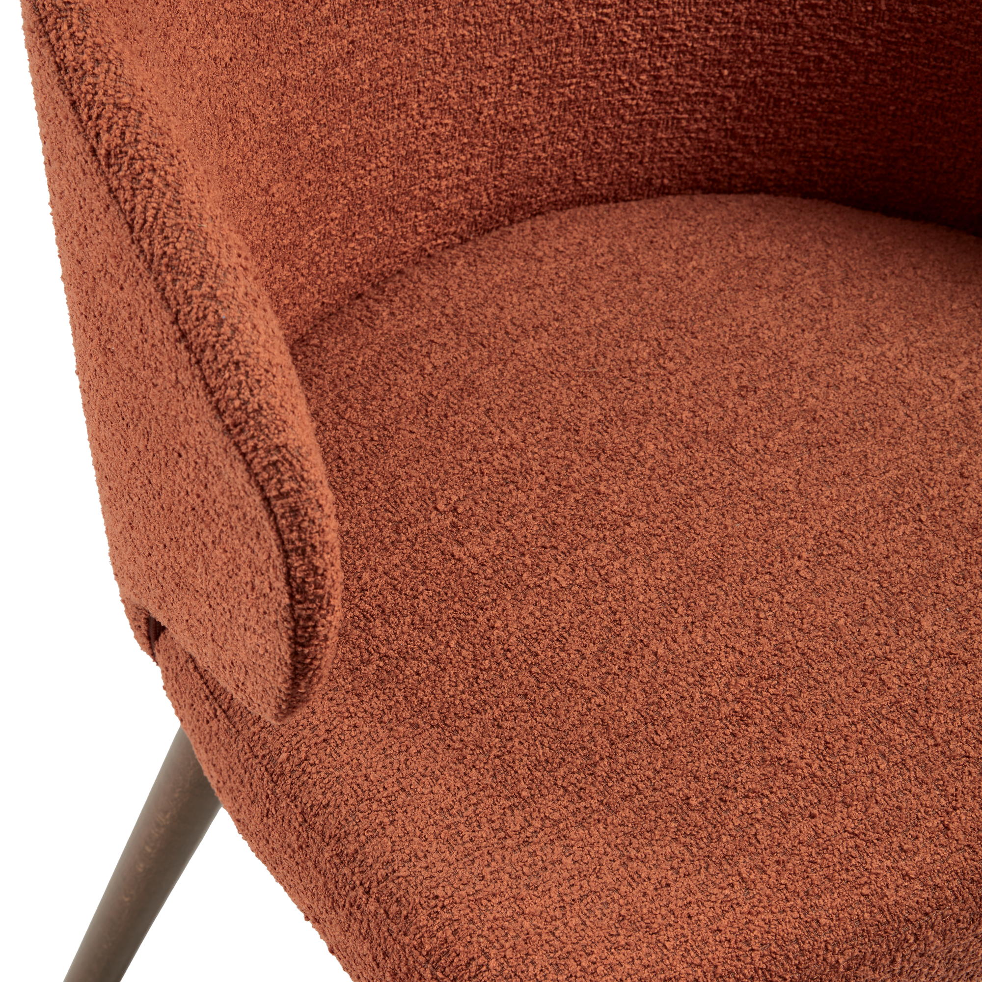 Close-up detail of the textured upholstery and cushioned seat of the Selma Armchair - Terracotta, showcasing its warm terracotta fabric and modern design.