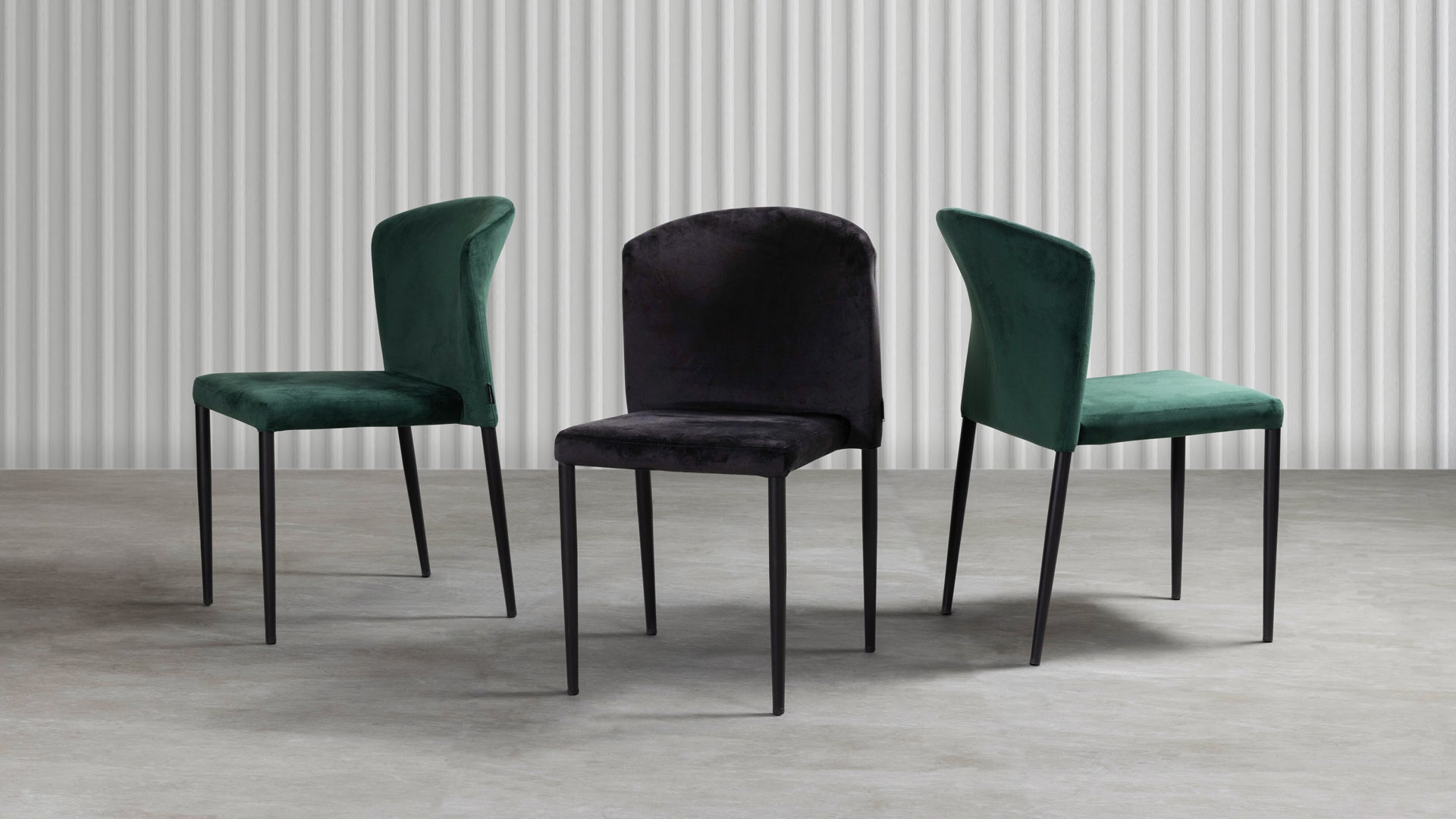 Three Veneto Stacking Side Chair - Black Velvet chairs arranged in a studio setting, showcasing their sleek black velvet upholstery and slim metal legs against a neutral background.